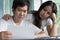 Family financial crisis. Stressed asian couple looking at issues notification from bank about late payment home loan credit