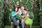 Family of four with bunch of flowers sit on bench