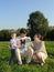 Family of four on grass wood blue sky