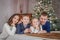 Family of four over cosy Christmas decoration