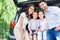 Family of four sitting in car trunk