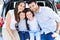 Family of four sitting in car trunk