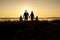 Family of four at sunset shadow black backlit