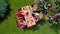 Family and friends eating together outdoors on summer garden party. Aerial view of table with food and drinks from above