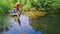 Family and friends fishing together outdoors near lake in summer, aerial top view from above