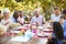 Family and friends talking over lunch at a table in garden