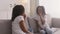 Family friendship. Cute african american girl resting on couch at home with mother, eating homemade cookies and talking