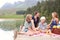 Family fun in the fresh air. Happy young family enjoying a lakeside picnic from a jetty.