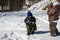 Family games in the snow in a forest glade. Adults and children in protective clothing. Carpathians. Ukraine.