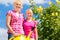 Family at gardening in front of rose bushes