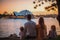 Family gathers in front of iconic city landmarks, bathed in the gentle glow of morning or evening sunlight