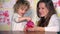 Family girls mother and daughter child having fun putting coins into piggy bank