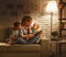 Family before going to bed mother reads children book about lamp