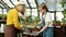 Family grandmother mother and daughter working in greenhouse together planting flowers