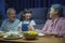 family grandparent and granddaughter dining on table and having fun during at