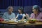 Family grandparent and granddaughter dining on table and having fun during at house