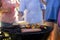 Family grilling patties, vegetables and sausages on the barbecue grill