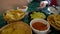 Family hands eating Mexican food corn nachos dipping salsa and avocado guacamole sauce