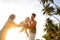 Family happily walk along a tropical beach at sunset