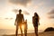 Family happily walk along a tropical beach at sunset