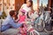 Family with happy kid having fun outdoor shopping new bicycle and helmets