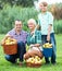 Family harvesting apples in garden