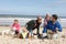 Family Having Barbeque On Winter Beach