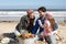 Family Having Barbeque On Winter Beach