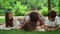 Family having fun in park. Children with parents lying on blanket in forest