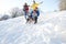 Family Having Fun Sledging Down Snowy Hill