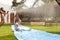 Family Having Fun On Water Slide In Garden