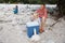 Family having a picnic in nature out of a cool box, sitting on the river bank