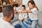 Family high five with hands raised up sitting on sofa at home
