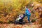 Family hiking with stroller in autumn park