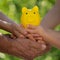 Family holding piggy bank in hands against green spring background