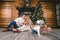 Family holiday New Year and Christmas. Young caucasian family mom dad son 1 year sit wooden floor near fireplace christmas tree on