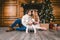 Family holiday New Year and Christmas. Young caucasian family mom dad son 1 year sit wooden floor near fireplace christmas tree on