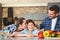 Family at home standing in kitchen together mother kissing son while father touching his head praising satisfied