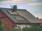 Family house with solar panels on the roof against blue sky