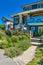 Family house with weedy front yard on blue sky background