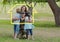 Family hugging each other in the park against house outline in background