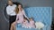 Family idyll, happy couple with children posing at photo session with two puppies on blue couch