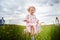 A family including two young parents and daughters on a walk in a meadow with grass and flowers. Dad, mom, girls relaxing and