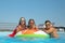 Family on inflatable ring in swimming pool
