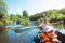 Family kayak trip. Father and daughter, and elderly couple senior and seniora rowing boat on the river, a water hike, a summer