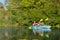 Family kayaking, mother and daughter paddling in kayak on river canoe tour having fun, active autumn weekend