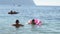 family kids boy and girl conflicting swimming in summer sea during leisure vacation activity