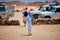 Family with kids, tourists going to off-road crossover cars during organized tour through the Sahara desert