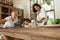 Family At Kitchen. Father And Son Using Tablet For Education While Mother Cooking Lunch. Interracial Parents And Kid.