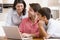 Family in kitchen with laptop smiling